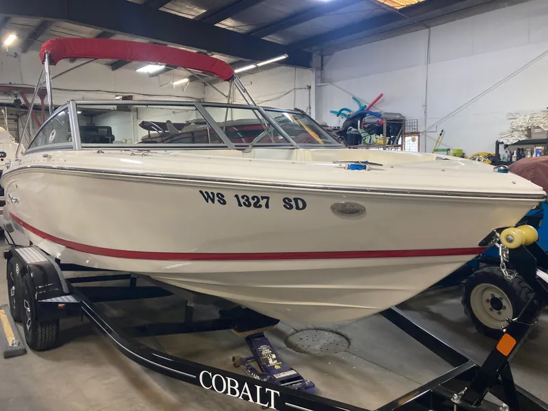 Slide: The Image of 2013 Cobalt 200 boat in warehouse with red canopy. - 9