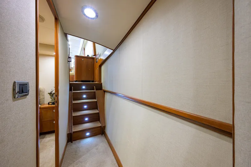 Slide: The Image of Interior hallway of 2003 American Custom Yachts Sport Fisherman with wooden stairs and soft lighting. - 32