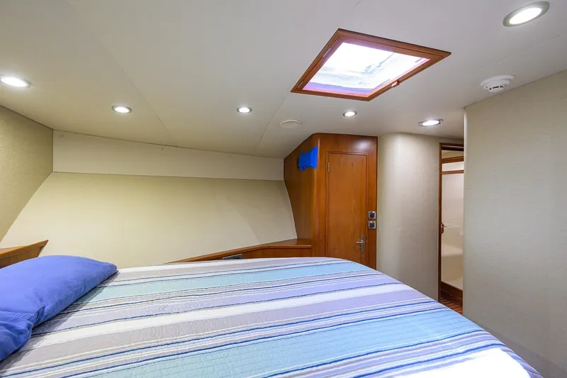 Slide: The Image of Luxurious cabin interior of 2003 American Custom Yachts Sport Fisherman with skylight and cozy bedding. - 35