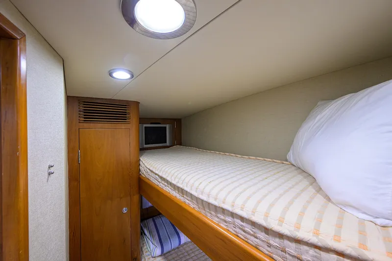 Slide: The Image of Cozy cabin interior of 2003 American Custom Yachts Sport Fisherman with bunk beds and TV. - 38