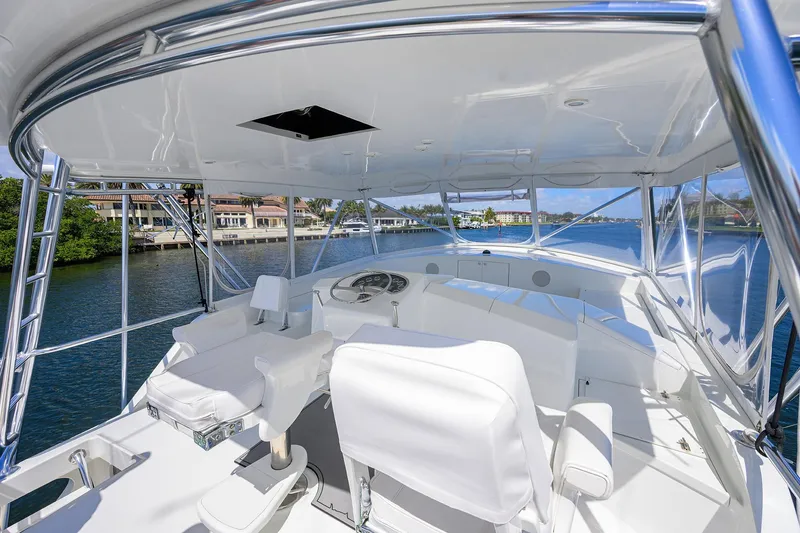 Slide: The Image of 2003 American Custom Yachts Sport Fisherman helm with white seating, overlooking serene waterfront. - 51