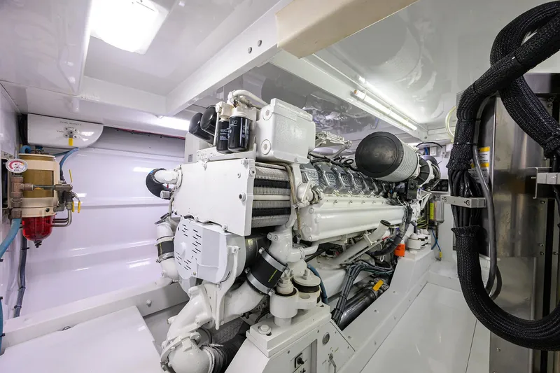 Slide: The Image of Engine room of a 2003 American Custom Yachts Sport Fisherman, showcasing a powerful marine engine. - 61