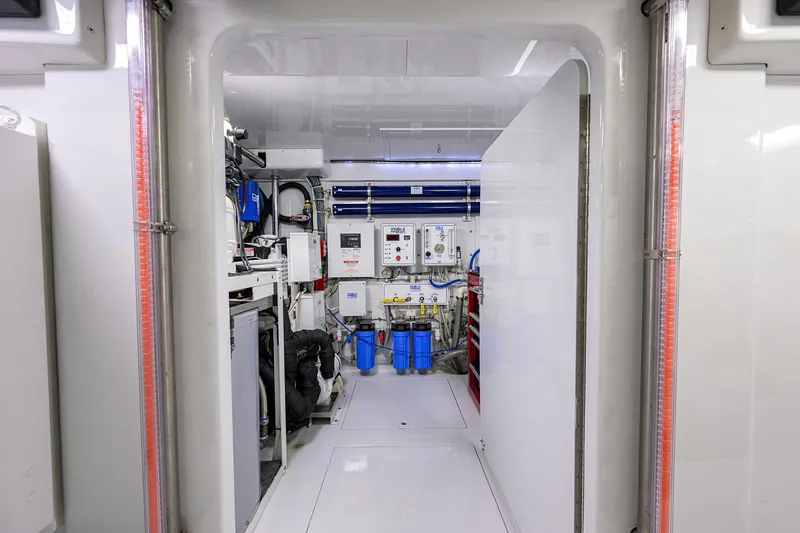 Slide: The Image of Engine room of a 2003 American Custom Yachts Sport Fisherman, featuring advanced equipment and controls. - 63