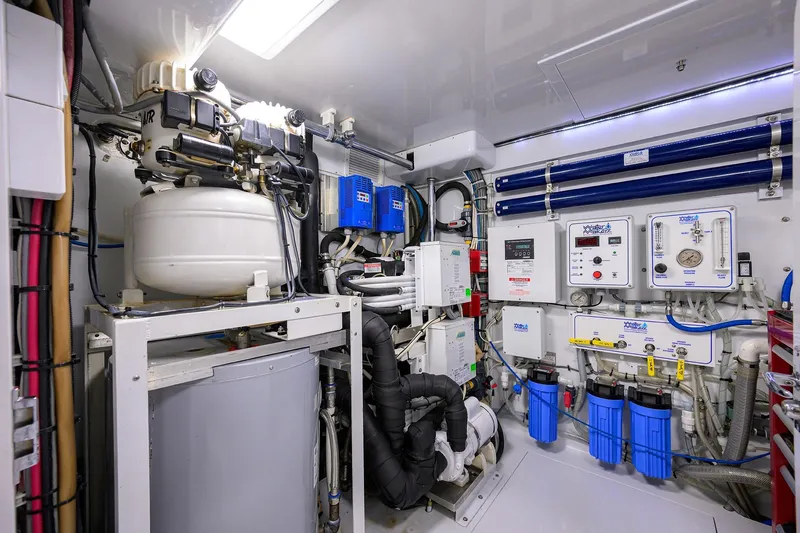 Slide: The Image of Engine room of a 2003 American Custom Yachts Sport Fisherman, showcasing complex machinery and equipment. - 64