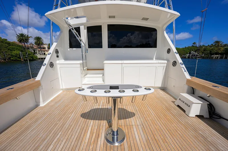 Slide: The Image of 2003 American Custom Yachts Sport Fisherman deck with fishing station, wooden flooring, and scenic water view. - 8
