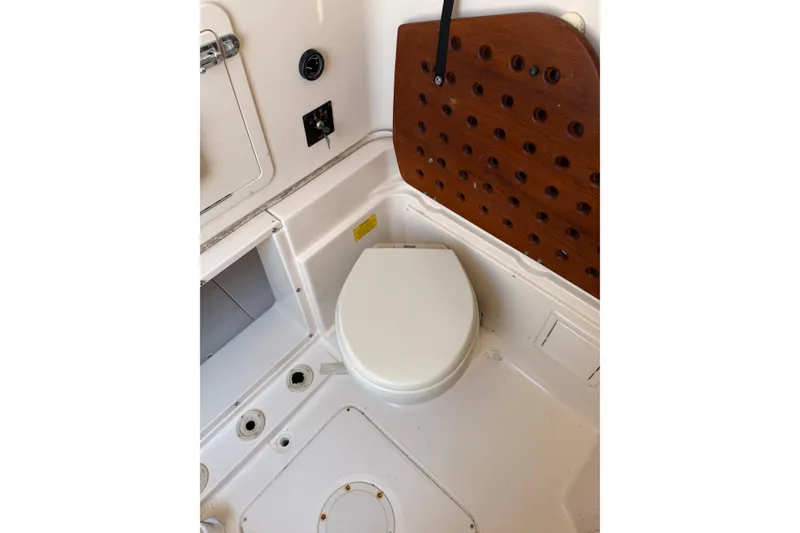 Slide: The Image of 2008 Grady-White Canyon 336 boat interior with toilet and wooden panel. - 29