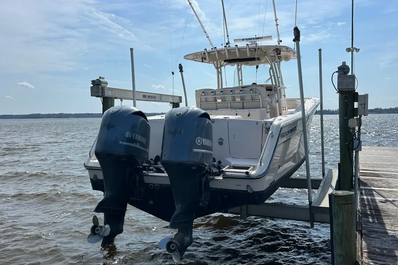 Slide: The Image of 2008 Grady-White Canyon 336 boat with twin Yamaha engines on a lift by the dock. - 3