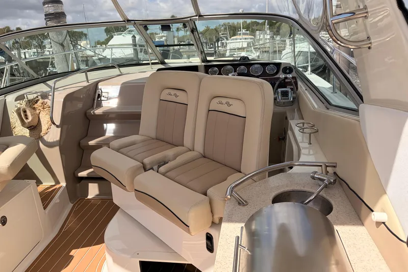 Slide: The Image of 2008 Sea Ray Sundancer 350 cockpit with beige seating and helm, docked at marina. - 9
