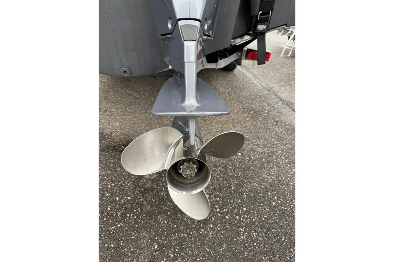 Slide: The Image of Propeller of a 2016 Pursuit DC 265 Dual Console boat on pavement. - 11