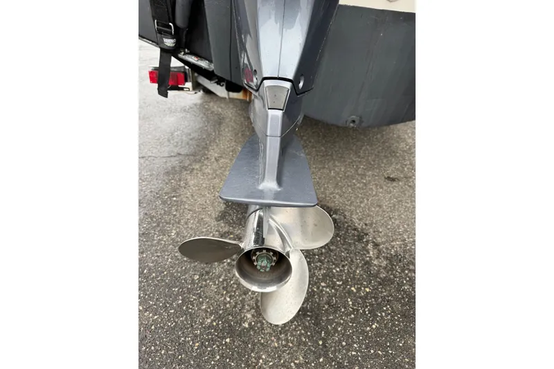 Slide: The Image of 2016 Pursuit DC 265 Dual Console boat propeller on wet pavement. - 12