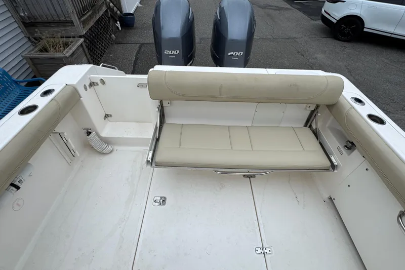Slide: The Image of 2016 Pursuit DC 265 Dual Console boat interior with beige seating and twin engines. - 17