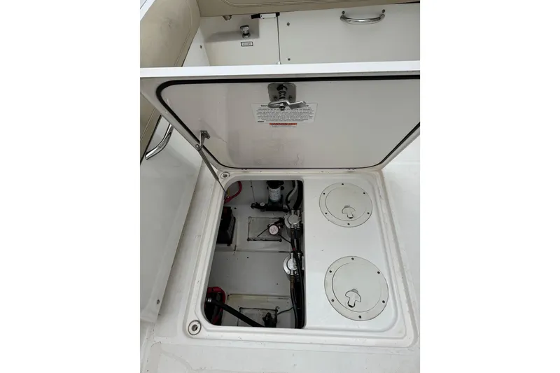 Slide: The Image of Open hatch of 2016 Pursuit DC 265 Dual Console boat, revealing internal components. - 18