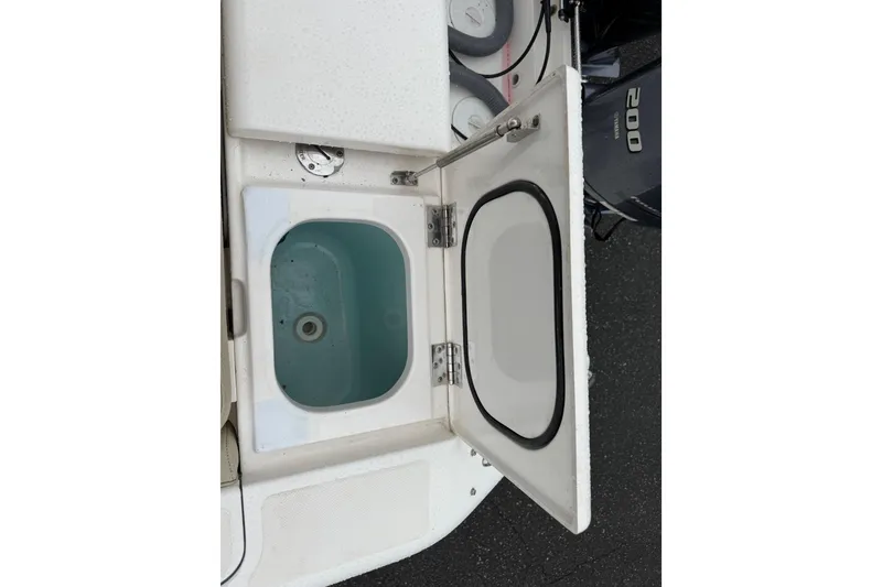 Slide: The Image of Open storage compartment on a 2016 Pursuit DC 265 Dual Console boat. - 22