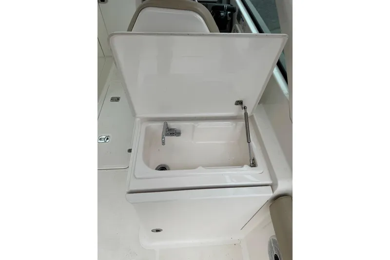 Slide: The Image of 2016 Pursuit DC 265 Dual Console boat sink with open lid and faucet. - 26