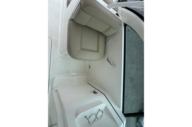Slide: The Image of 2016 Pursuit DC 265 Dual Console boat interior with beige seating and sleek design. - 30