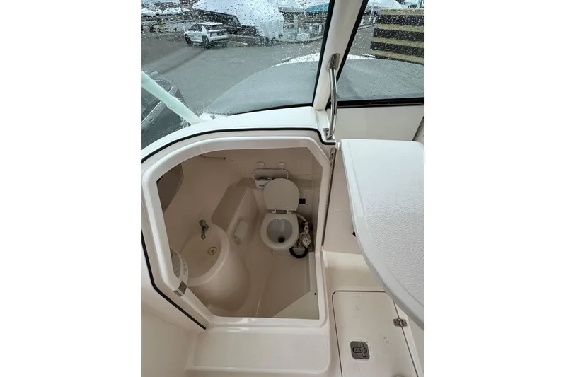 Slide: The Image of 2016 Pursuit DC 265 Dual Console boat interior with compact marine toilet. - 31