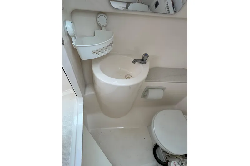 Slide: The Image of 2016 Pursuit DC 265 Dual Console boat bathroom with sink and toilet. - 32