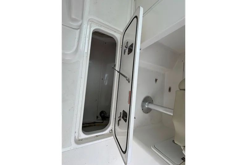 Slide: The Image of Open storage compartment on a 2016 Pursuit DC 265 Dual Console boat. - 35