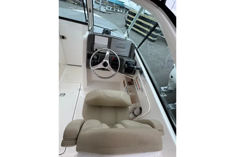 Slide: The Image of 2016 Pursuit DC 265 Dual Console boat interior with Garmin navigation system and beige seating. - 36