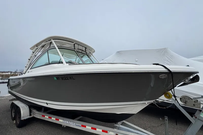 Slide: The Image of 2016 Pursuit DC 265 Dual Console boat on trailer, gray hull, parked outdoors. - 4