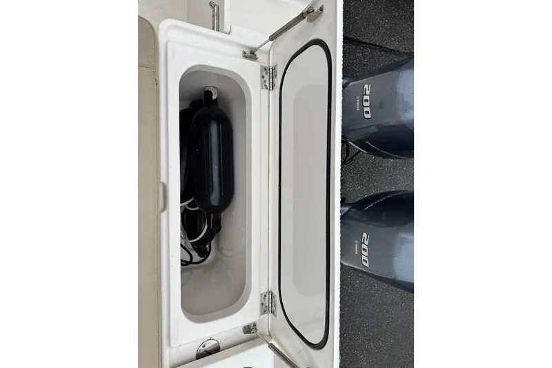 Slide: The Image of Storage compartment on a 2016 Pursuit DC 265 Dual Console boat with twin 200 engines. - 44