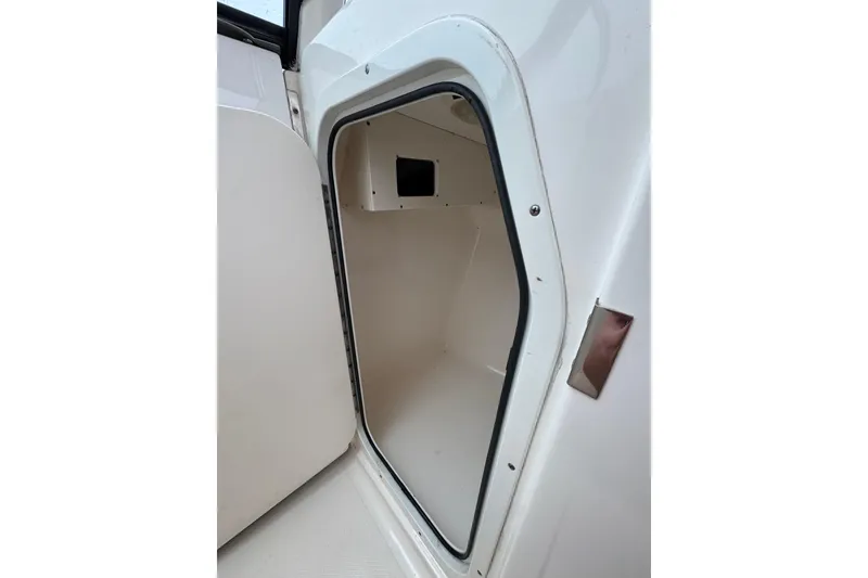 Slide: The Image of 2016 Pursuit DC 265 Dual Console storage compartment with open door. - 45