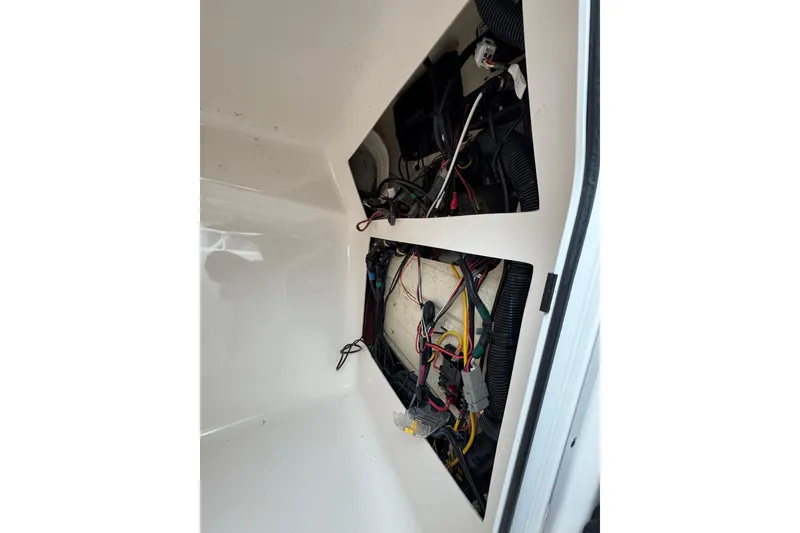 Slide: The Image of 2016 Pursuit DC 265 Dual Console boat wiring compartment with visible cables and components. - 46