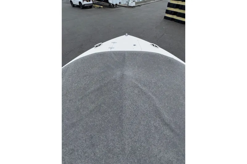 Slide: The Image of 2016 Pursuit DC 265 Dual Console boat bow with cover in a parking area. - 8