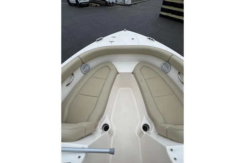 Slide: The Image of 2016 Pursuit DC 265 Dual Console boat interior with beige seating and speakers. - 9