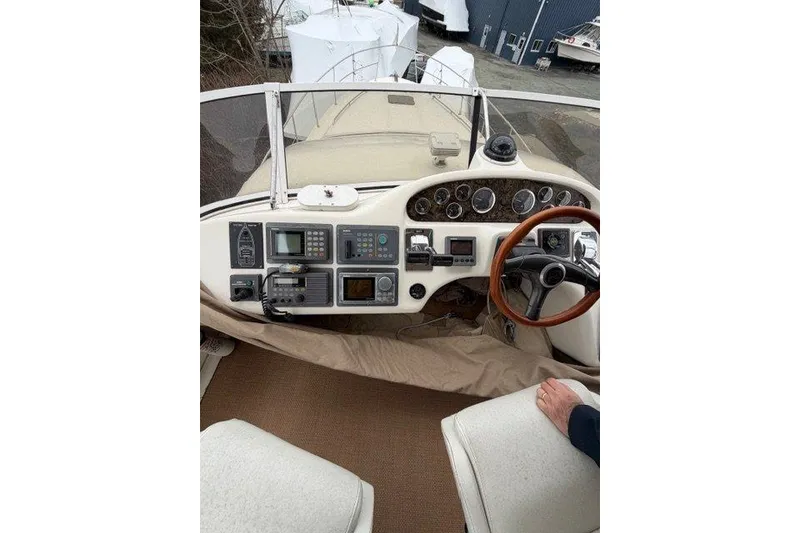 Slide: The Image of 1997 Sea Ray 400 Sedan Bridge helm with navigation instruments and wooden steering wheel. - 10