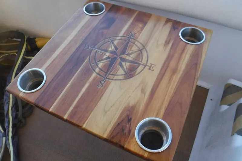 Slide: The Image of Wooden table with compass design and cup holders on a 1997 Sea Ray 400 Sedan Bridge. - 11