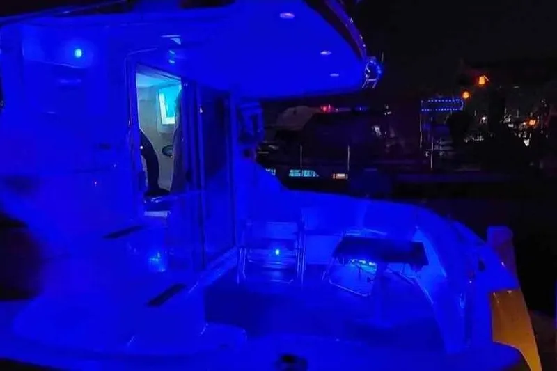 Slide: The Image of 1997 Sea Ray 400 Sedan Bridge yacht illuminated with blue LED lights at night. - 13