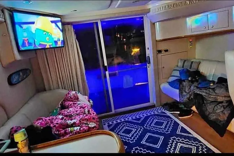 Slide: The Image of Interior of a 1997 Sea Ray 400 Sedan Bridge with cozy seating and a TV. - 3