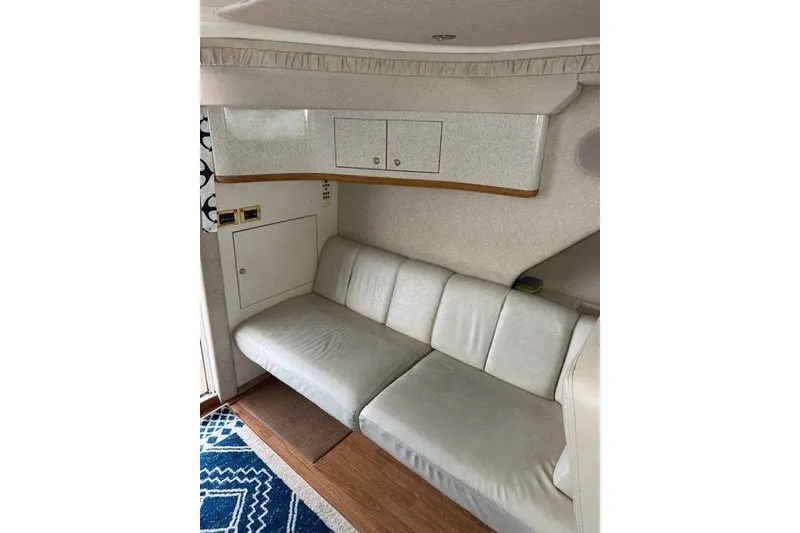 Slide: The Image of Interior of 1997 Sea Ray 400 Sedan Bridge with white leather seating and wooden accents. - 4