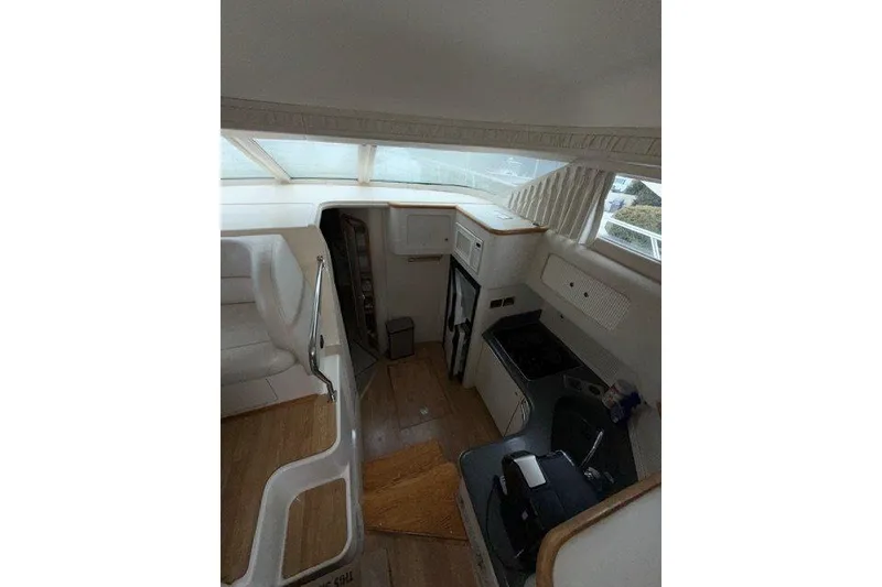 Slide: The Image of Interior of 1997 Sea Ray 400 Sedan Bridge yacht, featuring kitchen and seating area. - 6