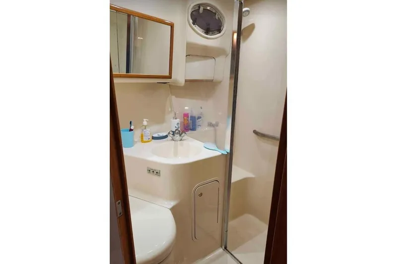 Slide: The Image of Bathroom interior of 1997 Sea Ray 400 Sedan Bridge yacht, featuring sink and shower. - 7