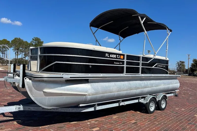 The Image of 2023 Cypress Cay Seabreeze 232 pontoon boat on trailer, parked on brick surface. - 1