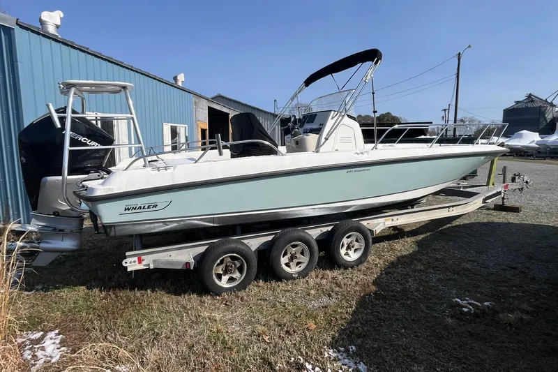 The Image of 2019 Boston Whaler 240 Dauntless boat on trailer, parked near blue building. - 0