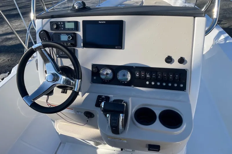 Slide: The Image of 2019 Boston Whaler 240 Dauntless boat console with steering wheel and navigation controls. - 10