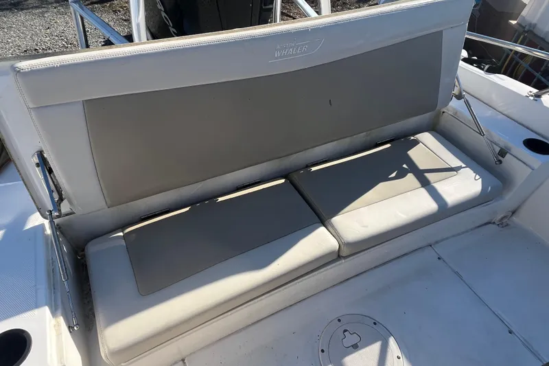Slide: The Image of 2019 Boston Whaler 240 Dauntless boat seating area with cushioned bench. - 12