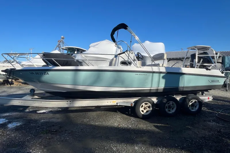 Slide: The Image of 2019 Boston Whaler 240 Dauntless boat on trailer, parked outdoors. - 14
