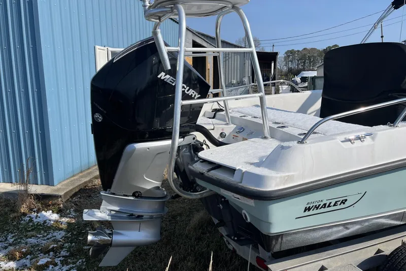 Slide: The Image of 2019 Boston Whaler 240 Dauntless boat with Mercury outboard motor, parked near blue building. - 6