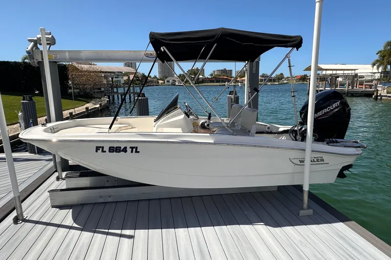 The Image of 2023 Boston Whaler 13 SS boat docked with Mercury engine, under sunny skies. - 0
