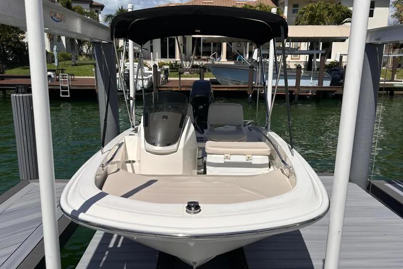 Slide: The Image of 2023 Boston Whaler 13 SS boat docked, featuring sleek design and canopy. - 2