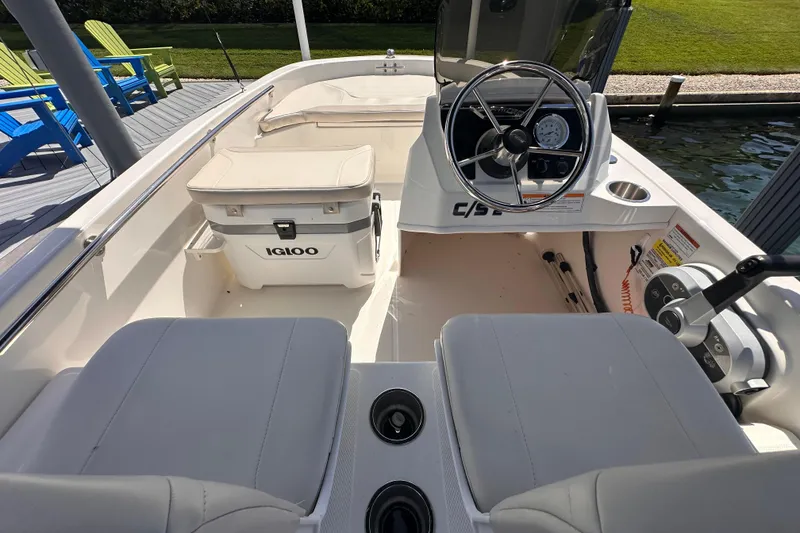 Slide: The Image of Interior of 2023 Boston Whaler 13 SS boat with steering wheel and Igloo cooler. - 4