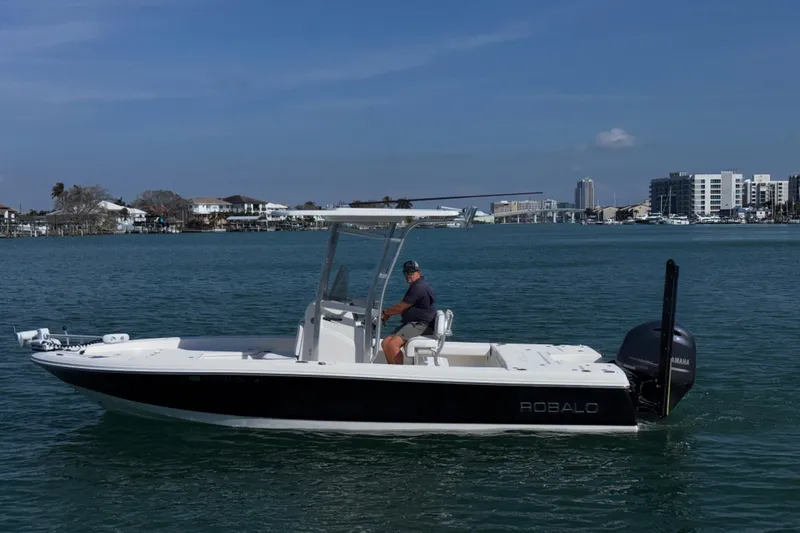 The Image of 2015 Robalo 226 Cayman boat on water, cityscape in background. - 0