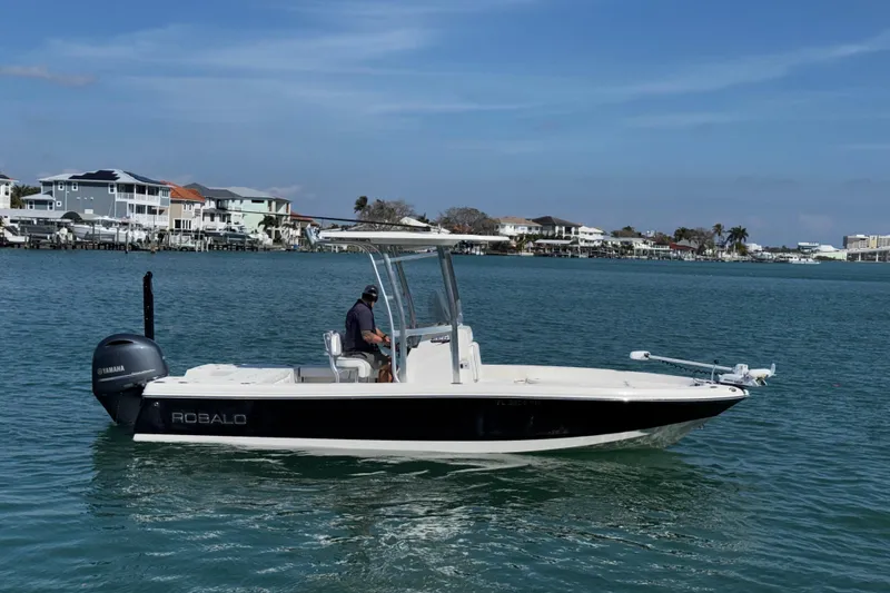 Slide: The Image of 2015 Robalo 226 Cayman boat on water, with Yamaha engine, near coastal homes. - 10
