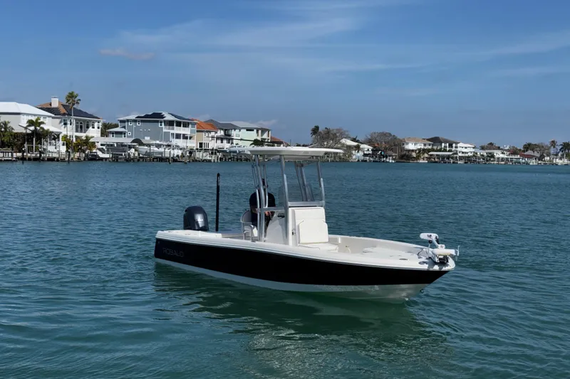 Slide: The Image of 2015 Robalo 226 Cayman boat on calm water near waterfront homes. - 13