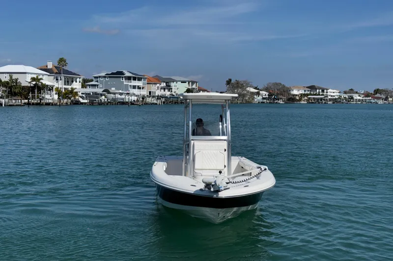 Slide: The Image of 2015 Robalo 226 Cayman boat on calm water near waterfront homes. - 15