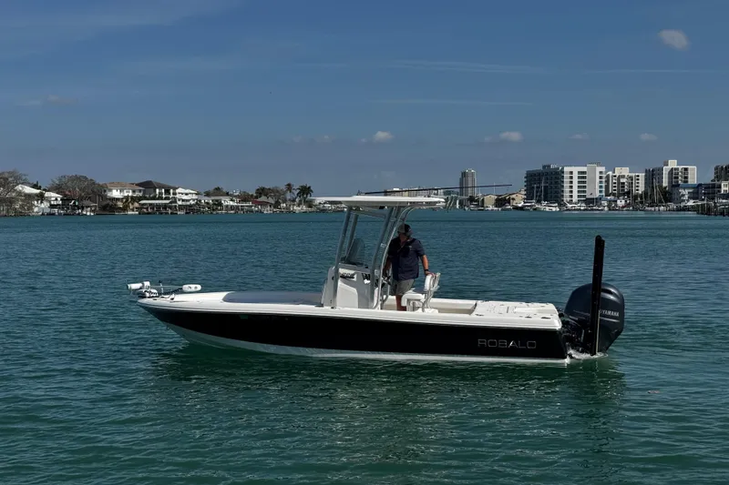 Slide: The Image of 2015 Robalo 226 Cayman boat on calm water with cityscape background. - 21